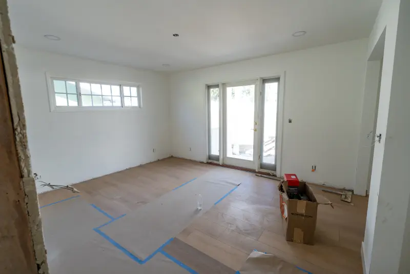Primary bedroom with new floors under protective paper